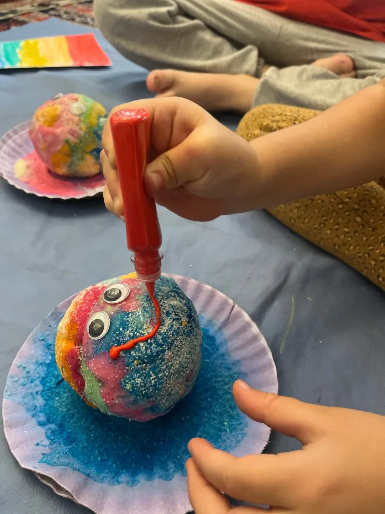 Criança criando arte com materiais coloridos e expressão livre